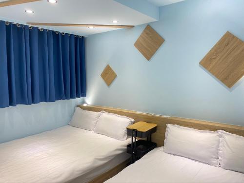 two beds in a room with blue walls at Sugar 5 in Jian