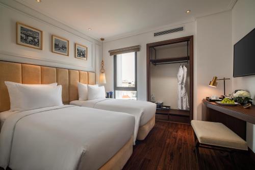 a hotel room with two beds and a television at Soleil Boutique Hotel Hanoi in Hanoi