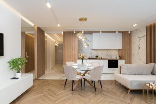 cocina y sala de estar con mesa y sofá en GA Luxury Apartments G9, en Cracovia