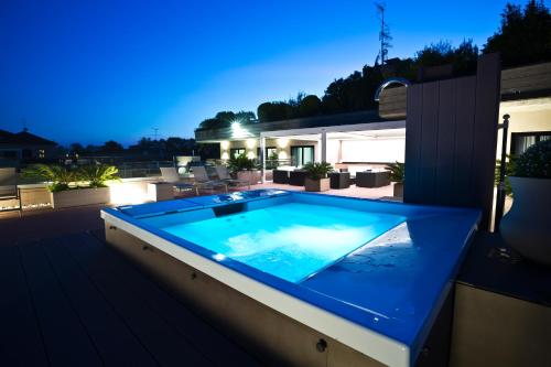 a swimming pool on the roof of a house at night at Hotel Desenzano in Desenzano del Garda