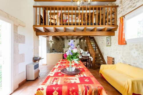 uma sala de estar com uma mesa e um sofá em Villa de 4 chambres avec piscine privee jardin amenage et wifi a Genissac em Génissac