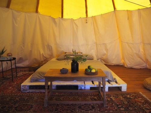 Habitación con cama y mesa con fruta. en Teepee Barranco, en Tindaya