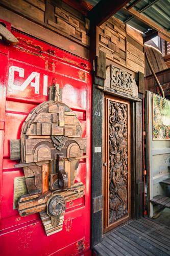 a red wall with a painting of a machine on it at Suankaew​ art​ hostel​ in Chon Buri