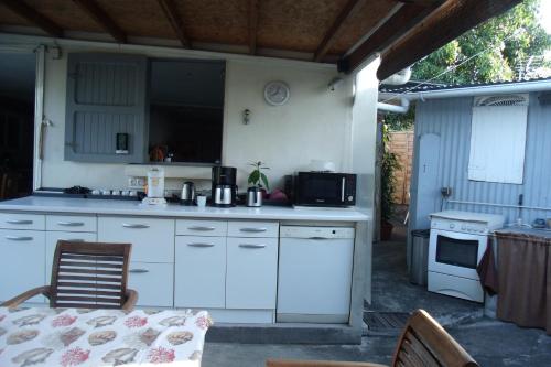 a kitchen with white cabinets and a table and a table and chairs at KazTiFahamAimée in Saint-Louis