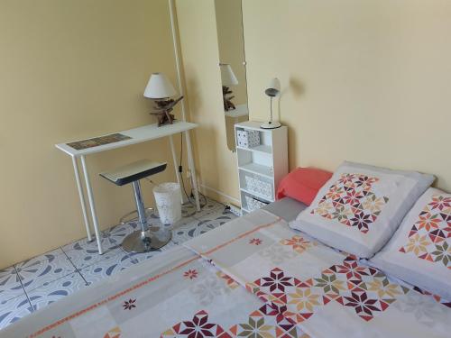 a small bedroom with a bed and a desk at KazTiFahamAimée in Saint-Louis