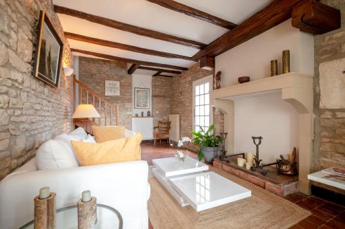 - un salon avec un canapé blanc et un mur en pierre dans l'établissement La 