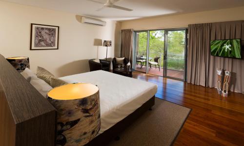 a bedroom with a bed and a living room at Cicada Lodge in Katherine
