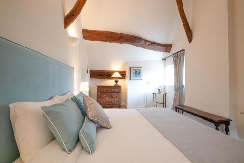 a bedroom with a large white bed with pillows at La "Petite" Maison in Saint-Romain