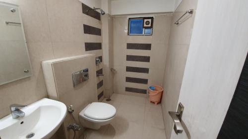 a small bathroom with a toilet and a sink at Hotel Purva in Indore
