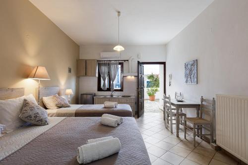 a hotel room with two beds and a kitchen at Kasteli Studios & Apartments in Panormos Rethymno