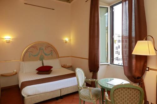 a bedroom with a bed and a table and a window at Residenza Gens Julia in Rome