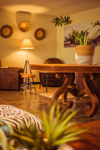 a living room with a table and a chair at Bushveld Terrace Safari Hotel, Lodge & Spa in Phalaborwa