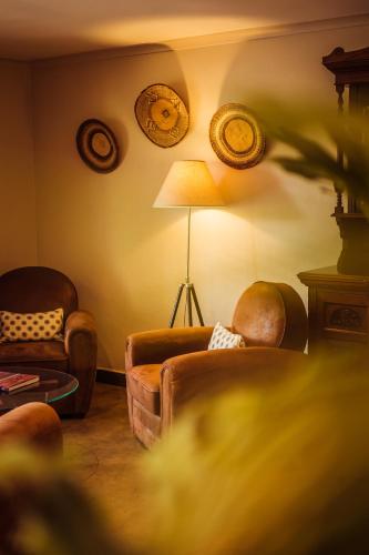 a living room with two chairs and a lamp at Bushveld Terrace Safari Hotel, Lodge & Spa in Phalaborwa