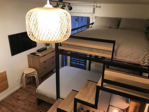 Cette chambre comprend des lits superposés et une lampe. dans l'établissement Studio cosy Disney/Paris. RER Val d’Europe à 150m, à Montévrain