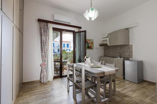 a kitchen with a table and chairs and a kitchen with a window at Kasteli Studios & Apartments in Panormos Rethymno