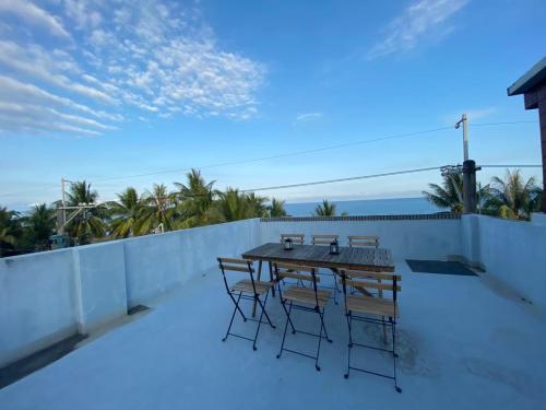 eine Terrasse mit einem Tisch und Stühlen auf dem Balkon in der Unterkunft 琉浪潛水背包客棧 Drift Diving Hostel in Xiaoliuqiu