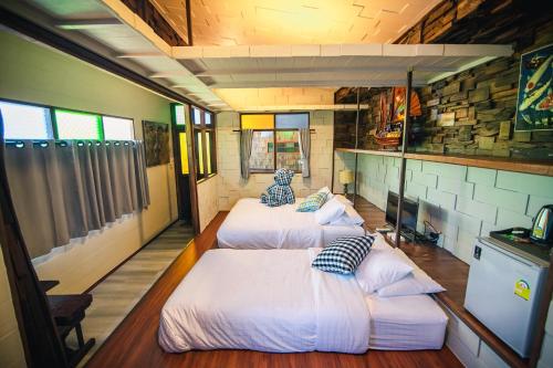 a group of three beds in a room at Suankaew​ art​ hostel​ in Chon Buri