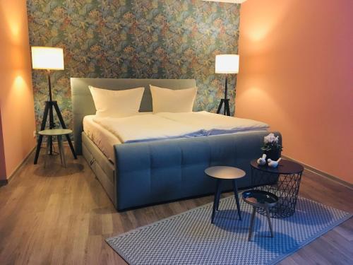 ein Schlafzimmer mit einem Bett, einem Tisch und zwei Lampen in der Unterkunft Pension Seecafé in Zarrentin