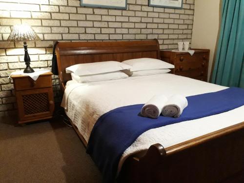 a bedroom with a large bed with towels on it at Die Plasie on-suite rooms in Hartbeespoort