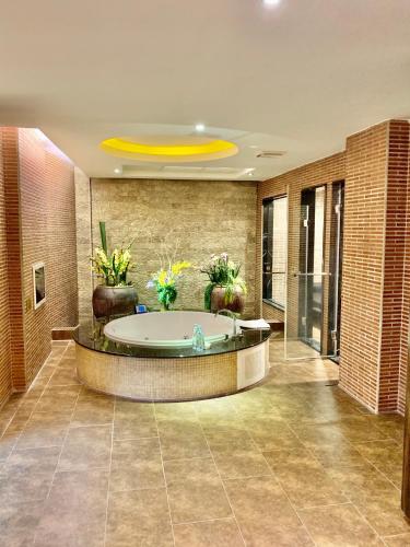 a large bathroom with a tub with plants in it at Merryseasons in Kaohsiung