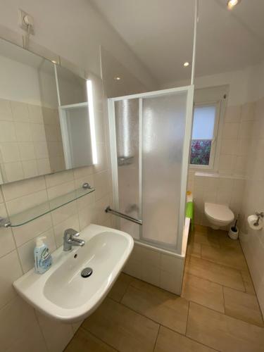 a white bathroom with a shower and a sink at familienfreundliche Ferienwohnung Maria in Duderstadt
