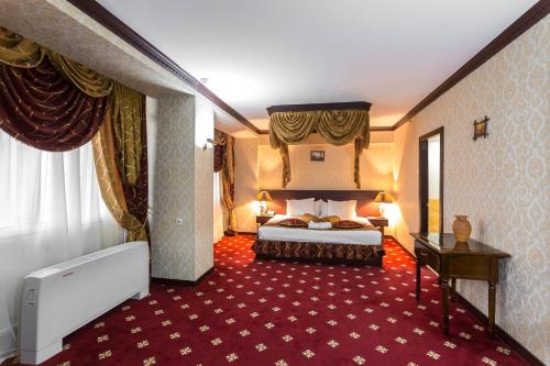 a hotel room with a bed and a red carpet at Hotel Uzbekistan in Tashkent