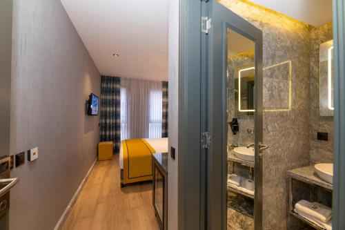een hotelkamer met een badkamer met een bed bij Peri Hotel Taksim in Istanbul