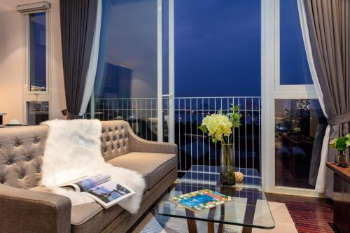 a living room with a couch and a glass table at Pegasy Premium Suites & Residence Westlake in Hanoi
