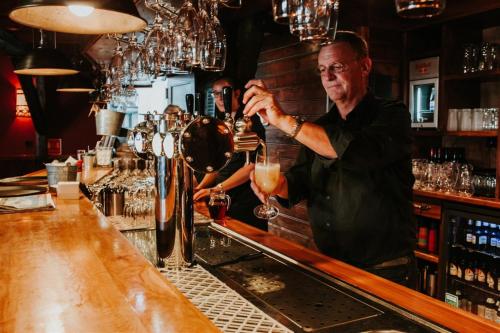 a bartender making a drink at a bar at Recreatiepark Jachthaven De Veerstal Lathum - Luxe Chalet in Lathum