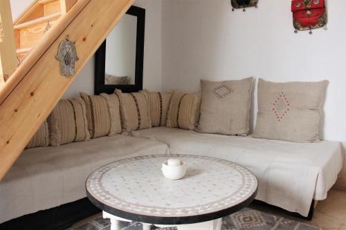 Riad El Ouarda في مراكش: غرفة معيشة مع أريكة وطاولة