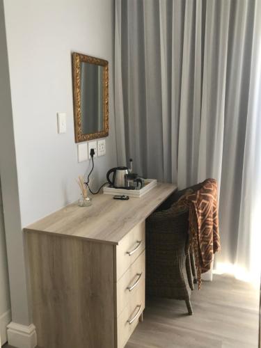 a wooden desk with a mirror in a room at Chartwell House in Velddrif