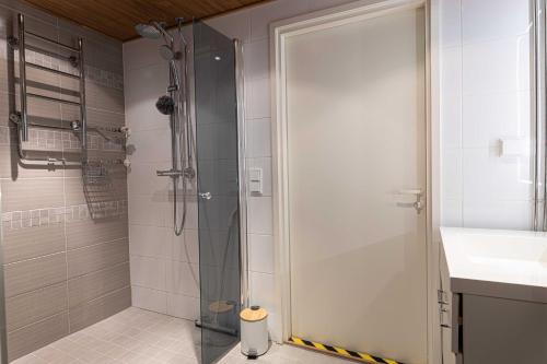 ein Bad mit einer Glasdusche und einem Waschbecken in der Unterkunft Apartment Rovakatu D28 in Rovaniemi