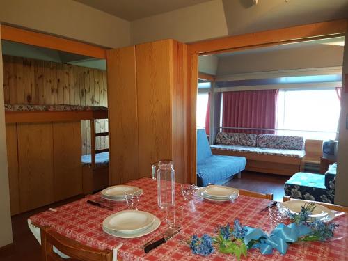 a dining room with a table and a living room at Res. Sole Alto appartamenti Solandra in Mezzana