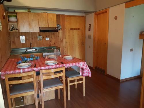 a kitchen with a table with chairs and a sink at Res. Sole Alto appartamenti Solandra in Mezzana