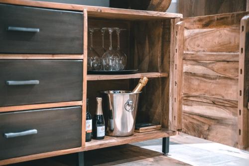 a wooden cabinet with wine bottles and a bucket at Merchant Signature Suites in Klaipėda