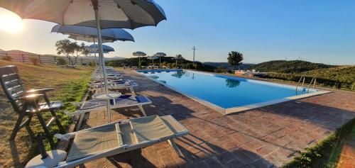 a swimming pool with chairs and umbrellas next to a pool at Hotel Tenuta dell'Argento Resort in Civitavecchia