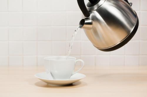 a tea kettle is pouring water into a cup at Hard Days Night Hotel in Liverpool