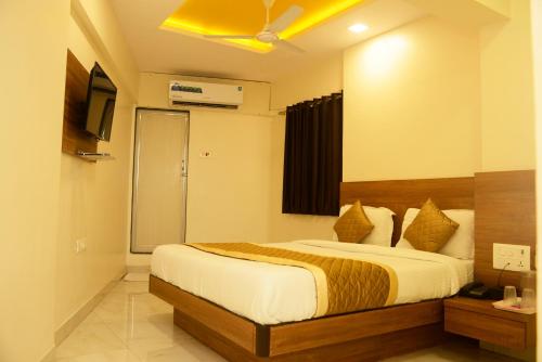 a bedroom with a bed and a television in it at Hotel Ashyana-Grant Road Mumbai in Mumbai