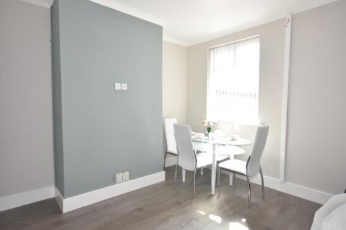 a white dining room with a table and chairs at Townhouse @ Penkhull New Road Stoke in Stoke on Trent