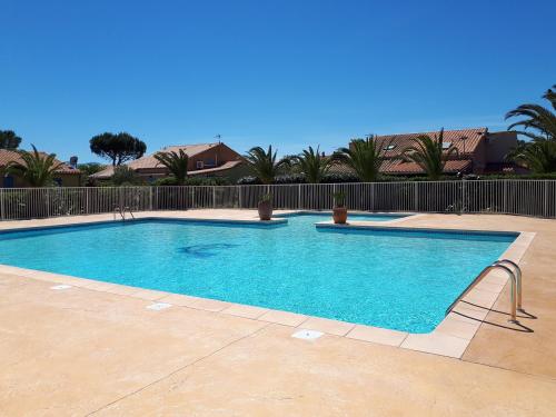duży błękitny basen na dziedzińcu w obiekcie Villa en duplex très calme en résidence privée avec piscine - M65 w mieście Saint-Cyprien