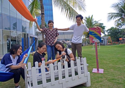 a group of people standing around a wooden fence at Resinda Hotel Karawang in Karawang