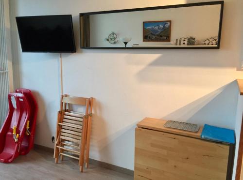 a room with a desk and a television on a wall at Studio pied des pistes in Villard-de-Lans