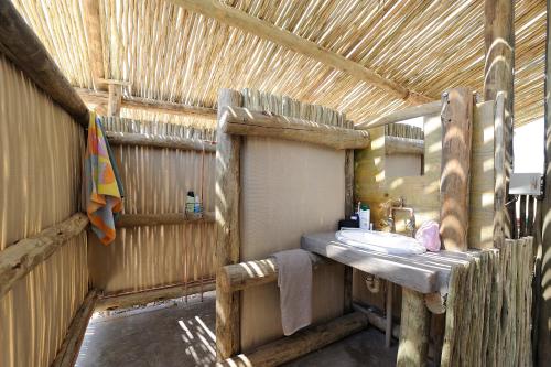 ein Badezimmer mit einem Waschbecken in einer Holzkonstruktion in der Unterkunft Sossus Oasis Campsite in Sesriem