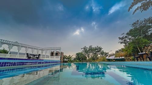 a swimming pool with blue water in front of a building at The Lal Bagh in Kumbhalgarh