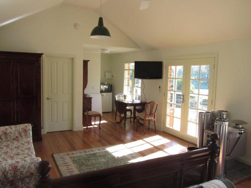 a living room with a table and a dining room at Honeyeater Cottage in Seville