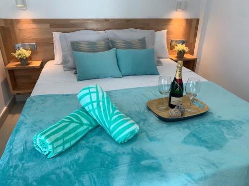 Una cama con dos copas y una botella de vino. en SUNNY DAY Deluxe 14, en La Playa de Arguineguín