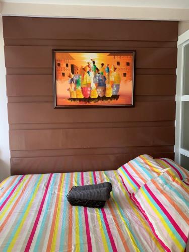 タガイタイにあるTagaytay Prime Residence -Citylandのベッドルーム1室(壁に絵画が描かれたベッド1台付)