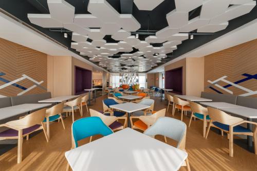 a dining room with tables and chairs at Holiday Inn Express Linyi North New District by IHG in Linyi