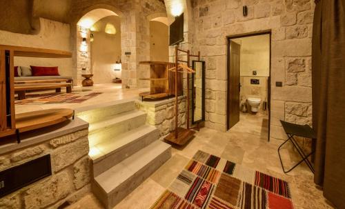 a large room with stairs and a bed and a bathroom at Luvi Cave Hotel in Goreme