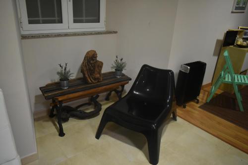 a black chair sitting next to a table with a chair at A Casa do Calexón in Viveiro